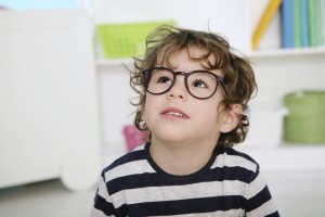 little boy with glasses looking up